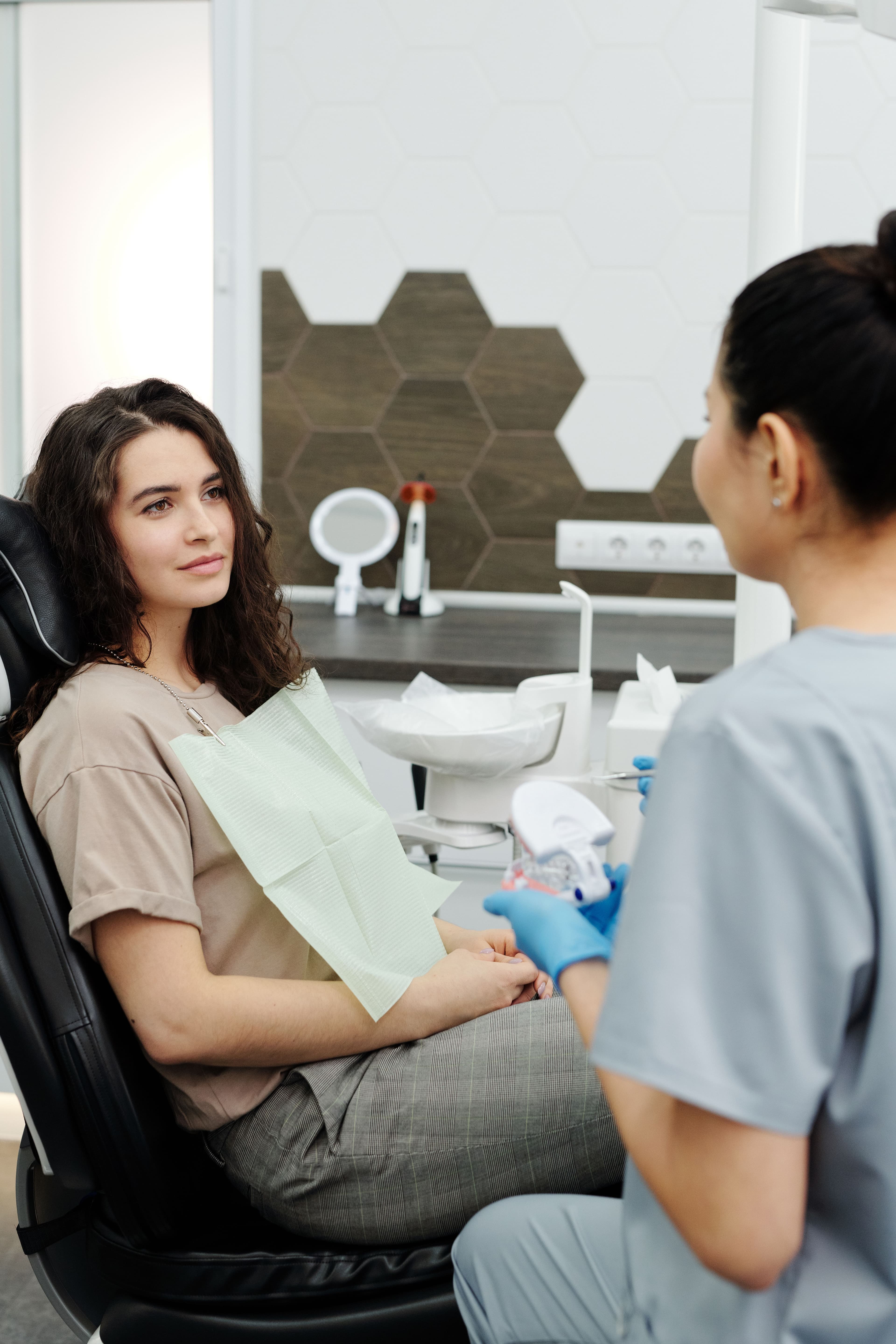 Dental professional consulting with a patient in a modern operatory